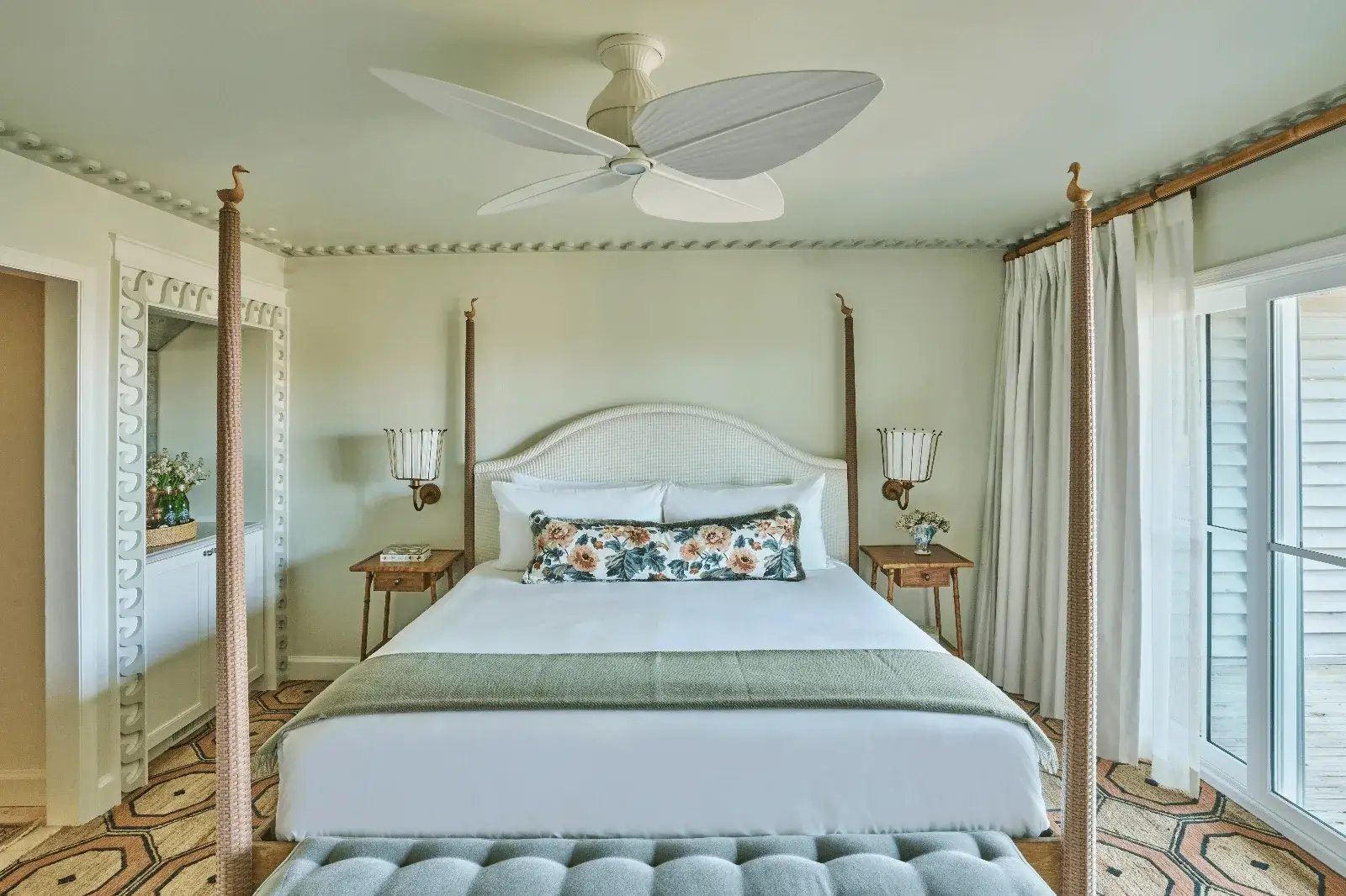 Room at The Sanderling Resort decorated in soft pastel green tones with geometric rugs and wooden furniture.
