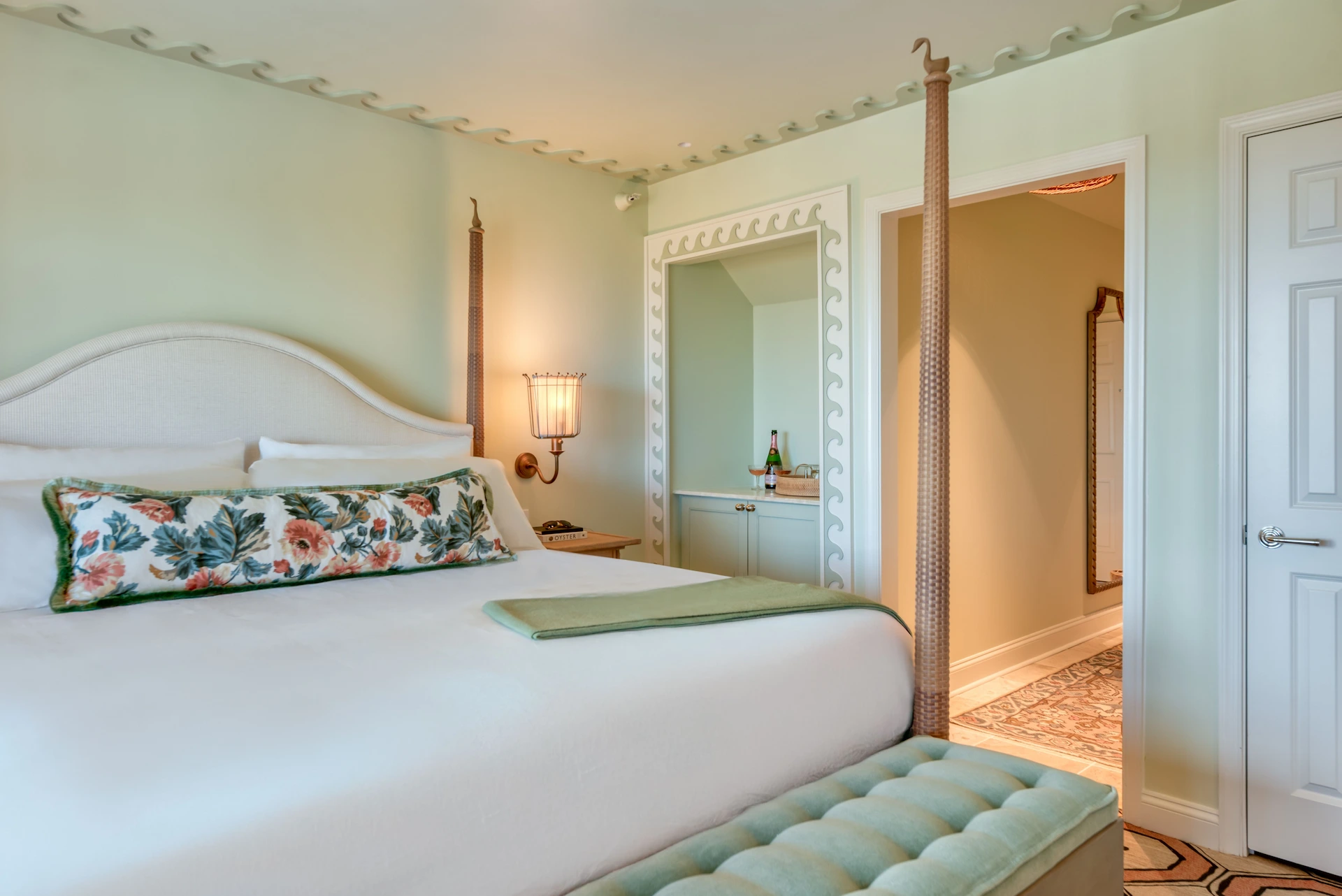 Suite at the Sanderling Hotel with a king-size bed and marine-themed decor in aqua green tones.