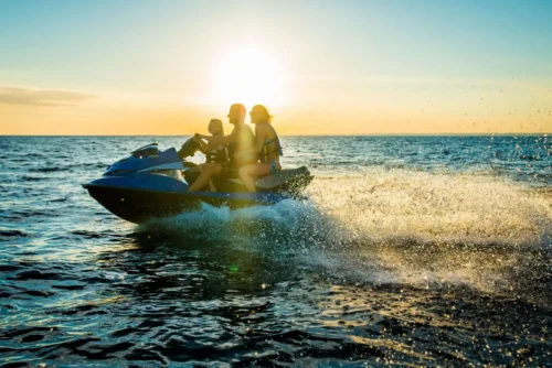 A family having a blast on jet ski, enjoying a fun-filled day under the bright, sunny sky.