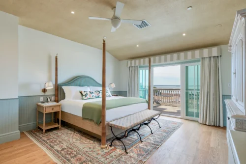 Spacious room with a king-size bed and a balcony offering stunning ocean views.