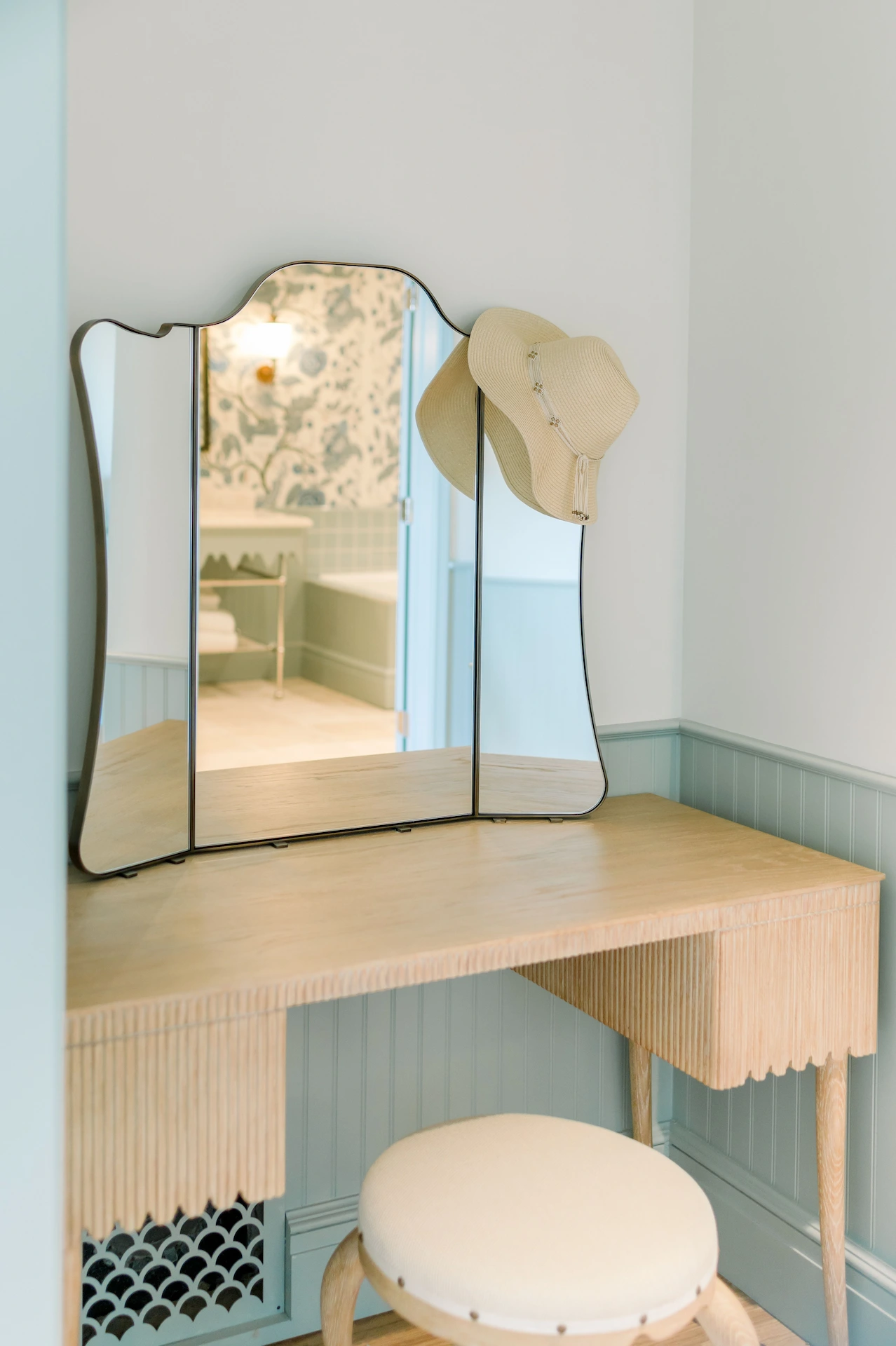 Charming sideboard with a mirror and a rustic straw hat, adding a cozy touch to the decor.