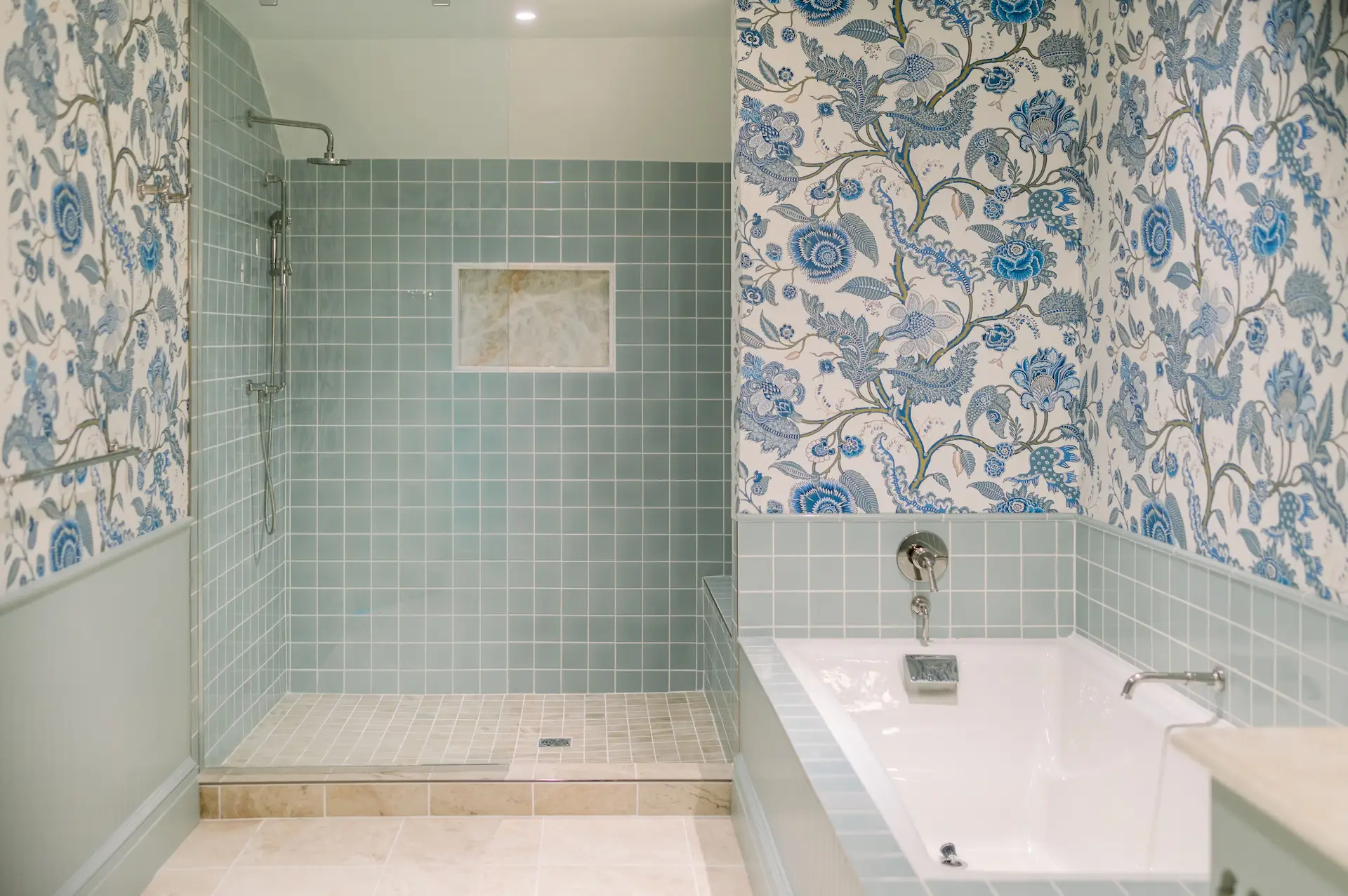 Elegant bathroom featuring a shower and bathtub, adorned with a beautiful floral motif on the walls and serene sea-green tiles.