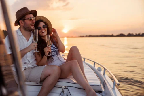 A couple enjoying a romantic Outer Banks cruise, sipping champagne as the sun sets.